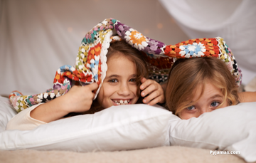 Young girl and boy in duvet fort 